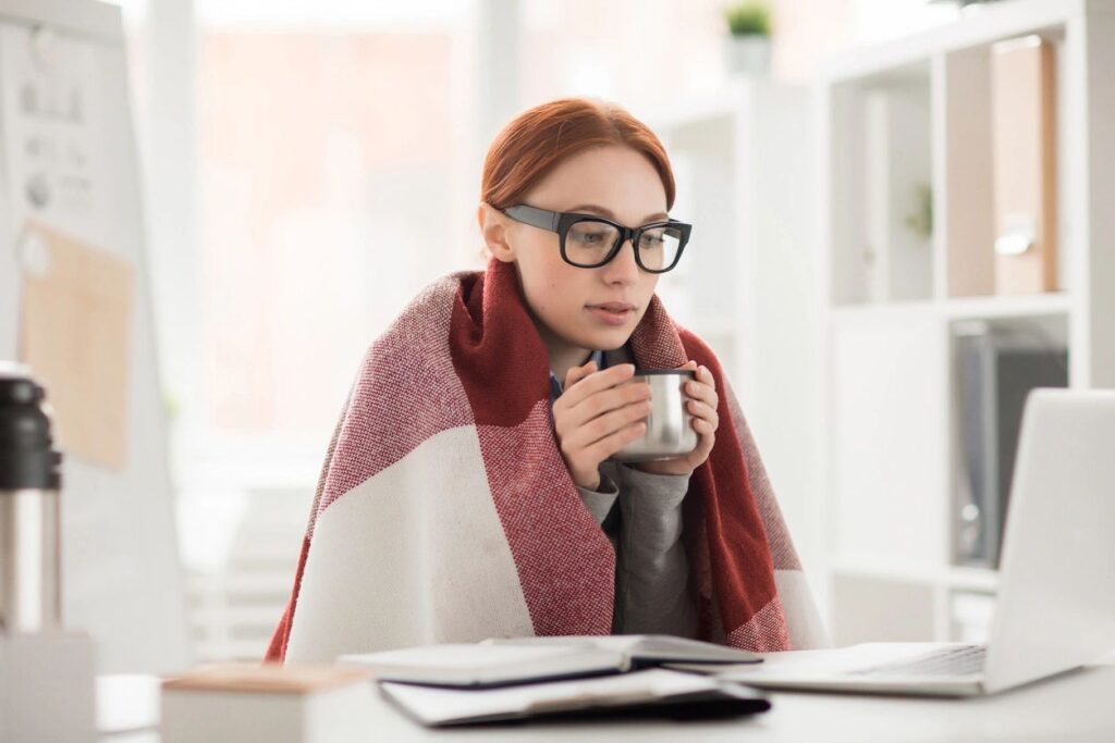 A young woman wrapped in a blacket trying to keep warm in her home - HVAC replacement or maintenance - Extreme HVAC Pros, Nashville TN